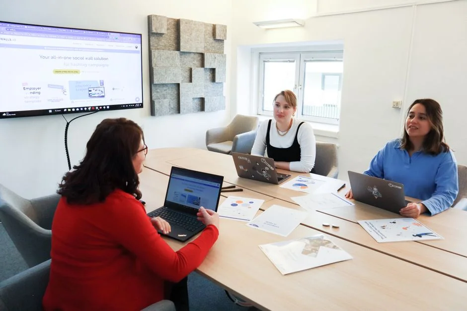 Hands exploring marketing strategy beside charts in an office environment.